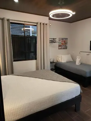 a bedroom with two beds and a window at MADRE TERRA in Uvita