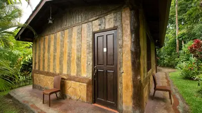 a door on the side of a house with two chairs at Orquideas Boutique Hotel in Fortuna