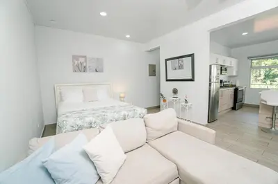 a living room with a couch and a bed at Apartamentos Ganesha Jacó in Jacó