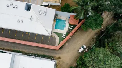 an overhead view of a building with a swimming pool at Apartamentos Ganesha Jacó in Jacó