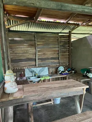 a large wooden table in a room with a kitchen at La Muñequita Lodge 1 - culture & nature experience in Palmar Norte