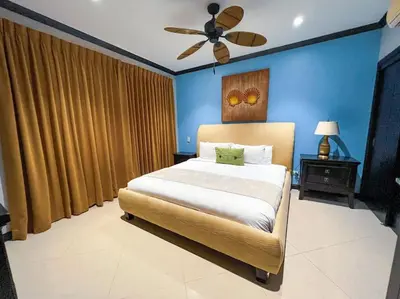 a bedroom with a large bed with a ceiling fan at Luxury Oceanfront Stay, Two Master Suites, Walk to Town in Jacó
