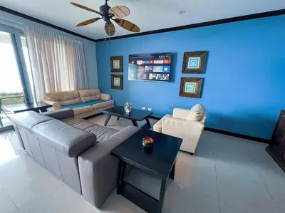 a living room with a couch and a blue wall at Luxury Oceanfront Stay, Two Master Suites, Walk to Town in Jacó