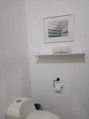 a white bathroom with a toilet and a mirror at Hotel Cañas in Cañas