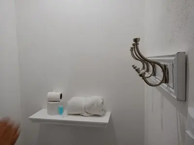 a white bathroom with towels on a shelf at Hotel Cañas in Cañas
