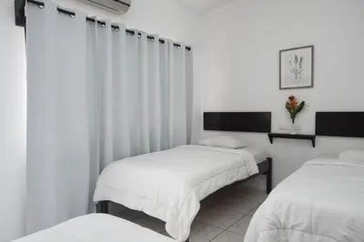 two beds in a room with white walls at Hotel Cañas in Cañas