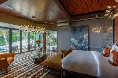 a bedroom with a large bed and a living room at Makanda by The Sea Hotel Adults Only in Manuel Antonio