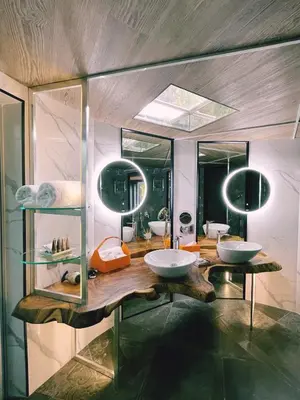 a bathroom with two sinks and two mirrors at Makanda by The Sea Hotel Adults Only in Manuel Antonio