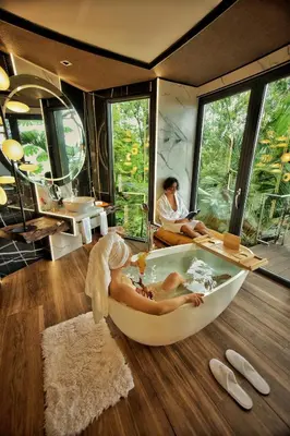 a woman sitting in a bath tub in a room at Makanda by The Sea Hotel Adults Only in Manuel Antonio