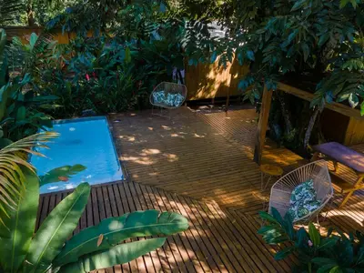 a patio with a swimming pool and two chairs at Seren Glamping in Uvita
