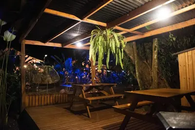 a patio with wooden tables and a palm tree at Seren Glamping in Uvita