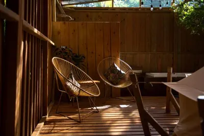 two chairs and a table on a wooden deck at Seren Glamping in Uvita