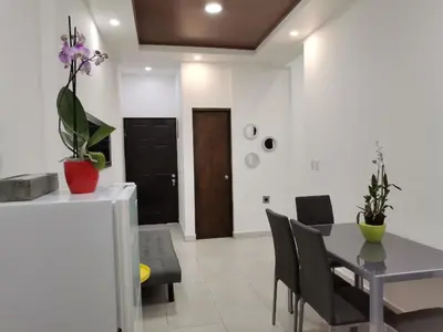 a dining room and living room with a table and chairs at 935 Lodge San José in San José