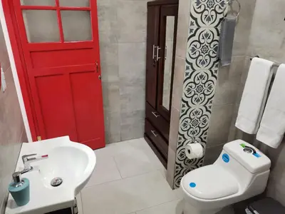 a bathroom with a red door and a white sink at 935 Lodge San José in San José