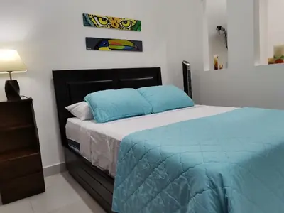 a bedroom with a bed with blue pillows on it at 935 Lodge San José in San José