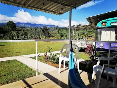a porch with a swing and a bus on it at Combi Bus Dreamcatcher in Sarchí
