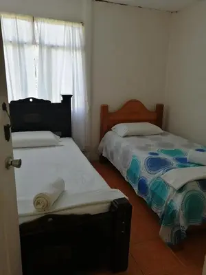 a bedroom with two beds and a window at Casa Los Ángeles in Ángeles