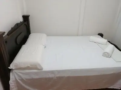 a white bed with two pillows on top of it at Casa Los Ángeles in Ángeles