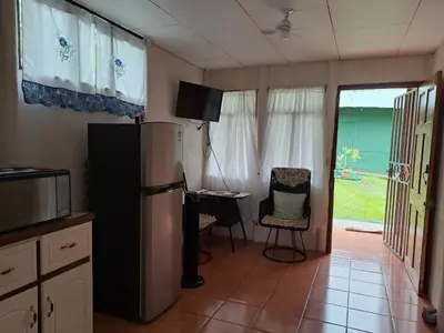 a kitchen with a refrigerator and a table and a chair at Casa Los Ángeles in Ángeles