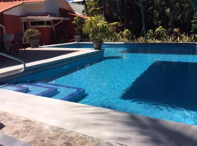 a swimming pool with blue water in front of a house at Villas Casa Carlos in La Abuela
