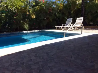 a swimming pool with two chairs and a swimming pool at Villas Casa Carlos in La Abuela