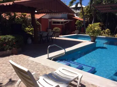 a swimming pool with two chairs next to a house at Villas Casa Carlos in La Abuela