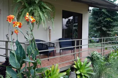 a porch of a house with chairs and flowers at Casa Zu in San Pedro