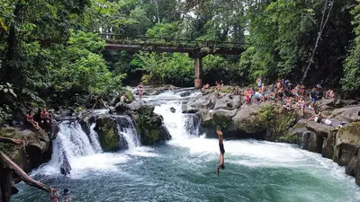 a group of people jumping in a waterfall at Casa Zu in San Pedro
