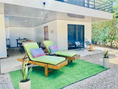 two lounge chairs and a fireplace in a yard at Casa Antema Tamarindo, maison luxe, piscine, jungle, yoga, gym in Tamarindo