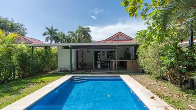 a villa with a swimming pool in front of a house at Pura Vida Villa! Beachfront Golf and Country Club Los Delfines 24 hours security in Tambor