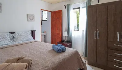 a bedroom with a bed with blue pillows on it at Pura Vida Villa! Beachfront Golf and Country Club Los Delfines 24 hours security in Tambor