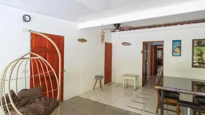 a living room with a red door and a table at Pura Vida Villa! Beachfront Golf and Country Club Los Delfines 24 hours security in Tambor