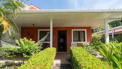 a home with an orange house with a porch at Pura Vida Villa! Beachfront Golf and Country Club Los Delfines 24 hours security in Tambor