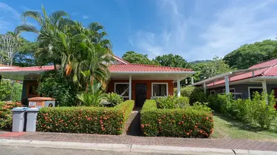 a house with trees and bushes in front of it at Pura Vida Villa! Beachfront Golf and Country Club Los Delfines 24 hours security in Tambor