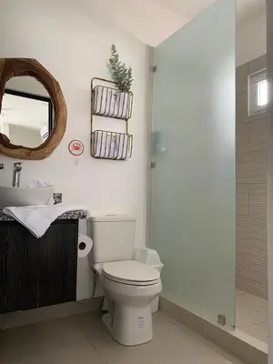 a bathroom with a toilet and a sink and a mirror at Jaco Lapa Living F2 in Jacó
