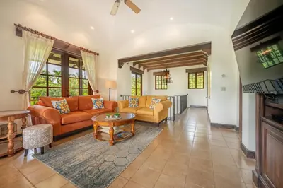 a living room with orange couches and a table at Dream House in prestigious Hacienda Pinilla in Tamarindo