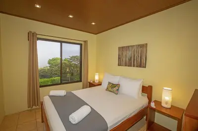 a bedroom with a large bed and a window at Beautiful 2 Bedroom Villa with Private Nature Reserve - Friendship House in Bijagua