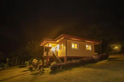 a small house on a hill at night at Beautiful 2 Bedroom Villa with Private Nature Reserve - Friendship House in Bijagua