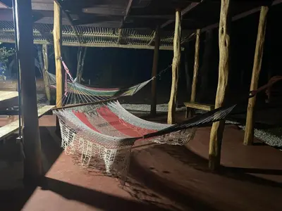 a hammock hanging from a pole in a room at Finca Avellanas in Playa Avellana