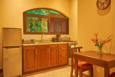 a kitchen with a refrigerator and a table and a window at One Bedroom Villa on 20 Acres of Nature! 