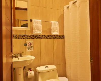 a small bathroom with a toilet and a sink at One Bedroom Villa on 20 Acres of Nature! 