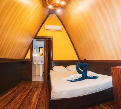 a room with two beds in a triangular shaped room at Termales del Arenal in Fortuna