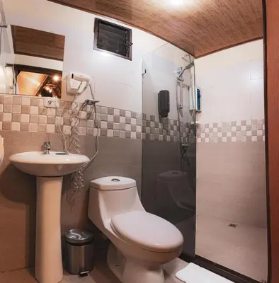 a bathroom with a toilet and a sink and a shower at Termales del Arenal in Fortuna