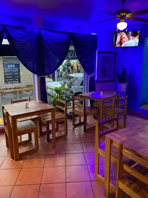 a dining room with tables and a tv on the wall at Park View Hotel & Restaurant in Alajuela City