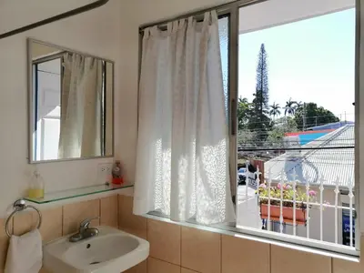 a bathroom with a sink and a window with a view at Park View Hotel & Restaurant in Alajuela City