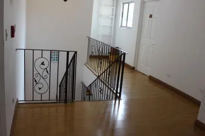 a hallway with a staircase with a wrought iron gate at Park View Hotel & Restaurant in Alajuela City