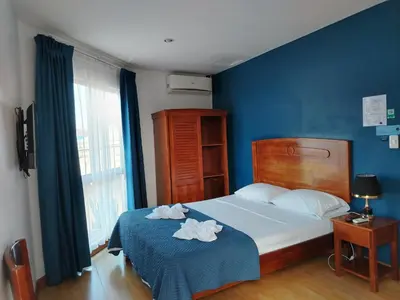 a bedroom with a bed with two towels on it at Park View Hotel & Restaurant in Alajuela City