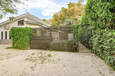 a fence in front of a ivy covered house at Casa Conchas in Carrillo