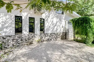 a white house with windows and a driveway at Casa Conchas in Carrillo