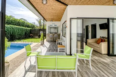 a patio with a table and chairs and a pool at Casa Conchas in Carrillo